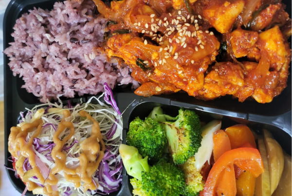 Spicy Dakgalbi Korean lunch box with purple rice, broccoli, and salad
